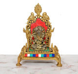 Brass pooja chowki with Ganesha idol, red tiled backdrop, gold arch, multicolor trim