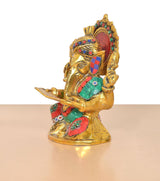 Side view metal Ganesha idol holding a scroll, jeweled crown and teal-and-red outfit