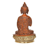 Brass Buddha idol rear view, detailed patterned robe, seated on ornate round pedestal