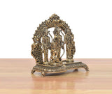 Brass ram darbar statue, angled view, three figures with ornate base and carved arch