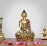Meditating Buddha statue in brass tone with jeweled multicolor robe and beaded seat