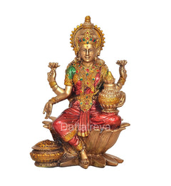 Lakshmi resin statue front view, ornate gold headpiece, green and red clothing, lotus seat