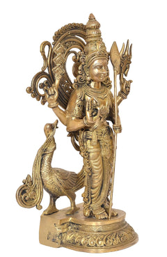 Brass Kartikeya Murugan figure standing beside decorative peacock support