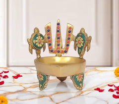 Brass oil lamp stand with chakra and naama motifs, teal enamel, 3-legged base