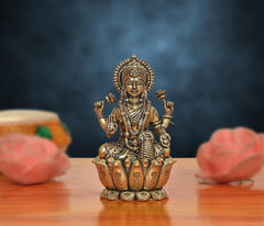 Bronze Lakshmi goddess idol, 4-armed seated on lotus, ornate detailing, 2.5 in