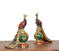 Brass peacock sculptures (2-pack), front-left view with red/blue body and floral green base