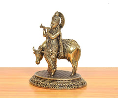 Lord Krishna brass statue on cow, flute in hand pose, engraved circular base