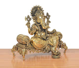 Brass Ganesha idol from front-left, raised hands and jeweled ornaments