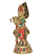 Brass Krishna playing flute idol statue, side angle showing blue halo and ornate red-green outfit.