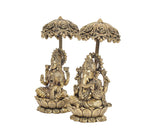 Brass Lakshmi and Ganesha statue pair, angled view under ornate chatri