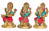 Side view of three brass deity idols with ornate crowns and teal & red detailing