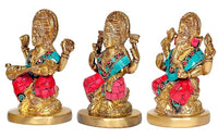Side view of three brass deity idols with ornate crowns and teal & red detailing