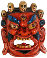 Mahakala wall hanging mask close-up: red demon face with blue accents and skull heads