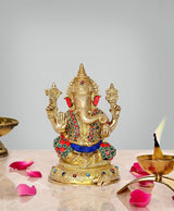 Brass Lord Ganesha idol with red trunk, jeweled crown and blue sash, seated stance.
