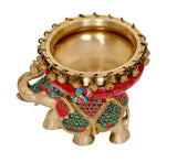 Brass elephant idol side view with red urli bowl and jeweled teal motifs