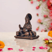 Copper Kuber idol statue, side view seated on pedestal with folded legs