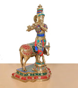Three-quarter view: Krishna on cow idol, detailed multicolor saddle and platform base