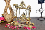 Brass swing idol Ganesha with side lamp bowls, chains, and ornate swing arch frame