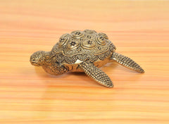 Brass tortoise figurine, angled view showing engraved shell and front feet