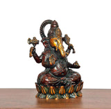 Lord Ganesha brass idol from angled view, detailed face, arms, and patterned lotus base