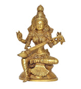 Brass Saraswati idol holding veena while seated in ornate sculpted attire