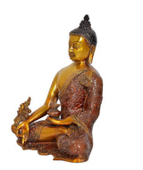 Gold Buddha statue meditating in profile, raised hand gesture, ornate brown robe