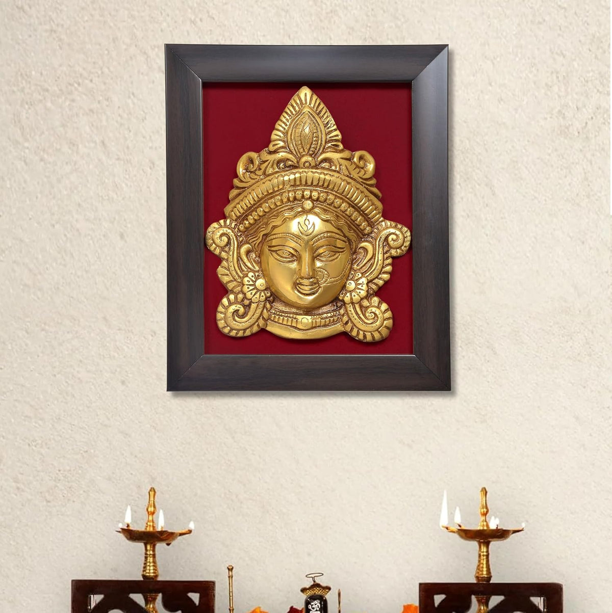 Brass Maa Durga face idol in dark wooden frame, gold relief on red backing