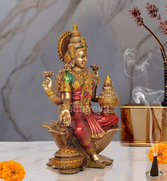Lakshmi resin statue kneeling on lotus, gold ornaments, green blouse and red sari with pot