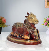 Seated Nandi bull statue with gold-toned head, red body, detailed patterns on base