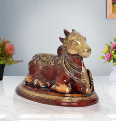 Seated Nandi bull statue with gold-toned head, red body, detailed patterns on base
