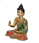 Side view meditating Buddha statue, gold face and hands, green robe with red patterned base.