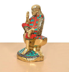 Side view of Shirdi Sai Baba brass statue with raised hand and multicolor striped attire