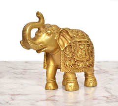Brass elephant figurine side view, raised trunk and decorative armor-like detailing