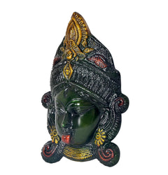 Brass Durga face idol mask close-up, dark green face with golden crown and ornaments