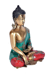 Brass Buddha statue seated with hands resting, turquoise sash and red-detailed cushion