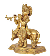 Brass Lord Krishna with flute, riding a cow, ornate base with engraved patterns