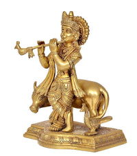 Brass Lord Krishna with flute, riding a cow, ornate base with engraved patterns