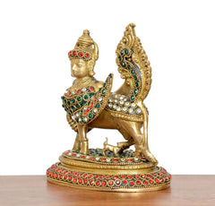 Brass Kamadhenu cow statue, winged back and jeweled red-green detailing