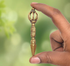 Brass Dorje Vajra Furba with three-pronged top, held in a hand