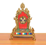 Brass pooja chowki with red arch, circular deity motif, multicolor patterned platform