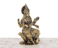Brass Maa Saraswati idol side/back view, seated on lotus with raised hands