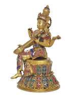 Brass Saraswati idol side view seated on lotus, veena in arms, jeweled pattern dress