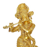 Close-up brass Krishna figurine playing flute, detailed face and raised flute