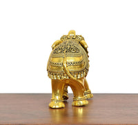 Golden brass elephant figurine, back view with ornate head cap and patterned torso