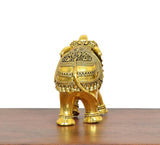 Golden brass elephant figurine from behind, patterned back and tail detail.