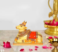 Resin Nandi cow idol, yellow with red saddle and gold details on base
