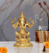 Brass Lord Ganesha idol with four arms, raised hands, seated on ornate pedestal
