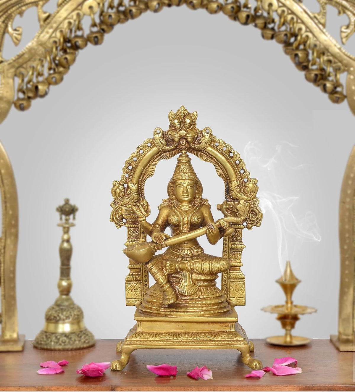Brass Saraswati idol statue holding veena, seated goddess figure on ornate base