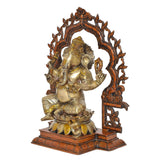 Brass Ganesha idol in profile, seated with raised right hand and carved arch