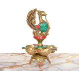 Side view of brass five-diya oil lamp stand, peacock on top with jeweled details